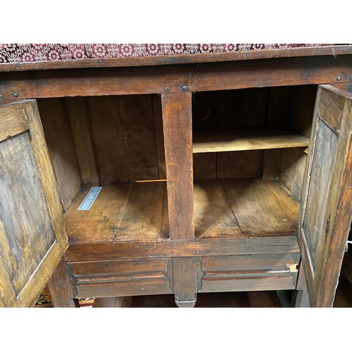 106B - A 17th century style oak buffet cupboard. Designed with two carved panel doors and single under draw... 