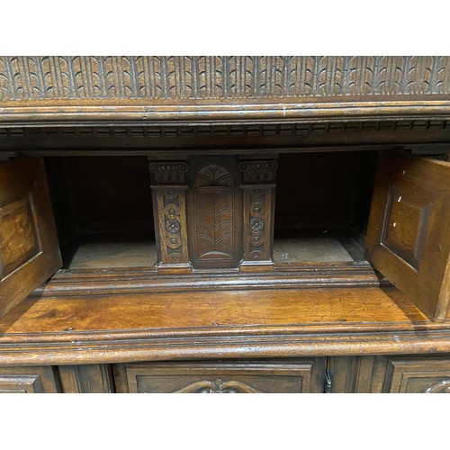 105B - An Impressive 17th Century style oak court cupboard unit. Showing detailed carved panel doors and tr... 