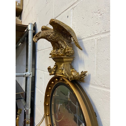 98A - A Regency style mirror fitted with moulded and wooden eagle finial, candle holders and acorn which a... 