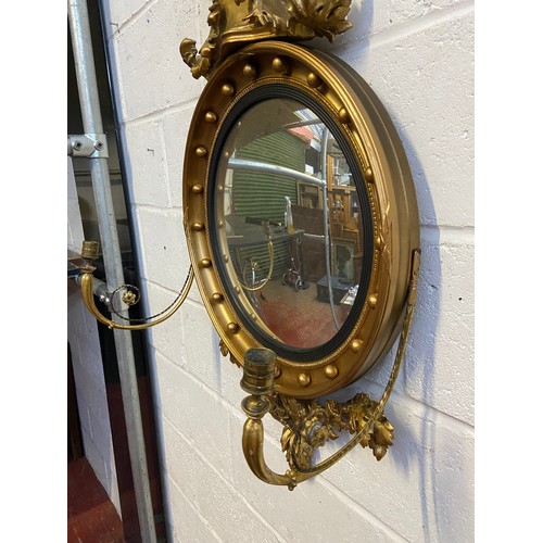 98A - A Regency style mirror fitted with moulded and wooden eagle finial, candle holders and acorn which a... 