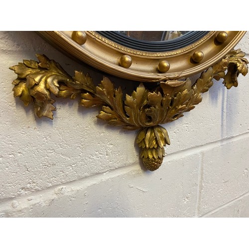 98A - A Regency style mirror fitted with moulded and wooden eagle finial, candle holders and acorn which a... 