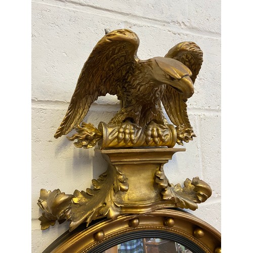 98A - A Regency style mirror fitted with moulded and wooden eagle finial, candle holders and acorn which a... 