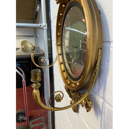 98A - A Regency style mirror fitted with moulded and wooden eagle finial, candle holders and acorn which a... 