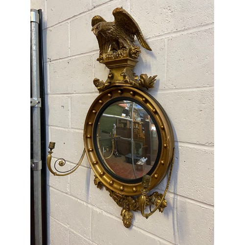 98A - A Regency style mirror fitted with moulded and wooden eagle finial, candle holders and acorn which a... 