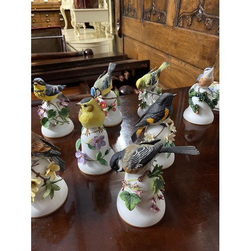 407B - A Collection of porcelain bird design bells together with four floral design wall plaques by Frankli... 