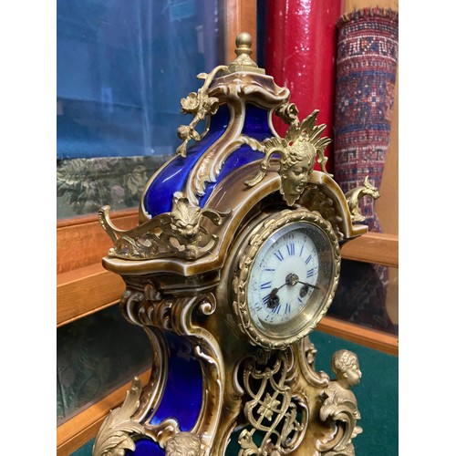 155A - An Antique Porcelain mantle clock designed with Ormalu mounts. White enamel face with blue roman num... 