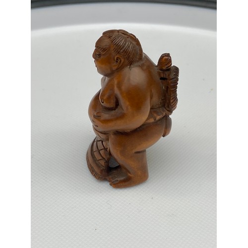 126J - A Japanese hand carved netsuke of a sumo wrestler, signed. [5cm in height]