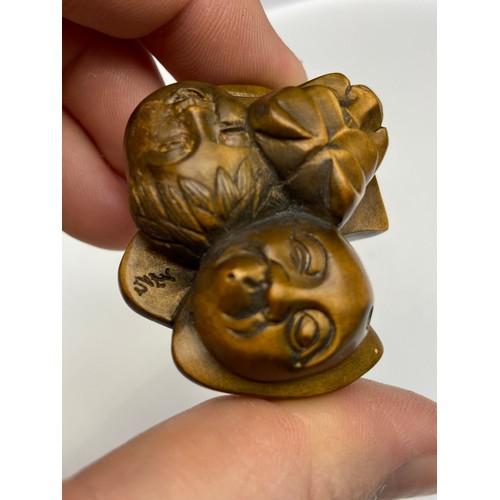 109J - A Japanese hand carved netsuke of 7 Oni masks clustered together. Signed. [4.5cm at widest point]