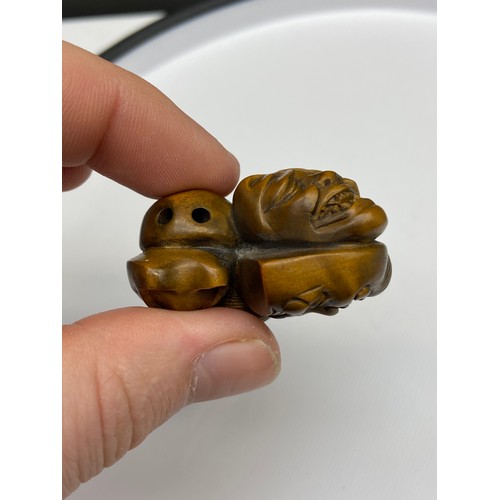 109J - A Japanese hand carved netsuke of 7 Oni masks clustered together. Signed. [4.5cm at widest point]