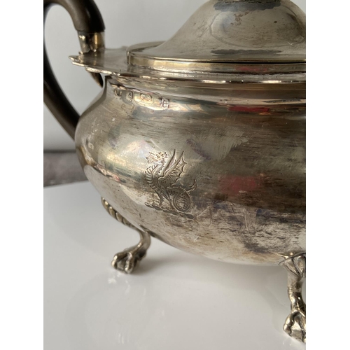 187J - A Birmingham silver teapot supported on claw & ball feet, engraved to the side showing a dragon insi... 