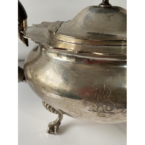 187J - A Birmingham silver teapot supported on claw & ball feet, engraved to the side showing a dragon insi... 