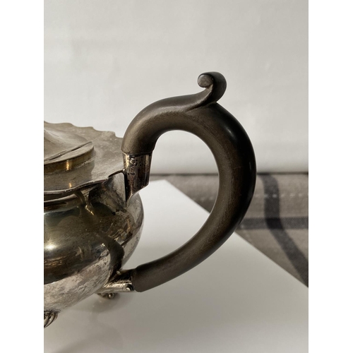 187J - A Birmingham silver teapot supported on claw & ball feet, engraved to the side showing a dragon insi... 