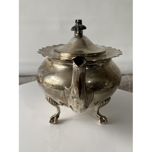 187J - A Birmingham silver teapot supported on claw & ball feet, engraved to the side showing a dragon insi... 