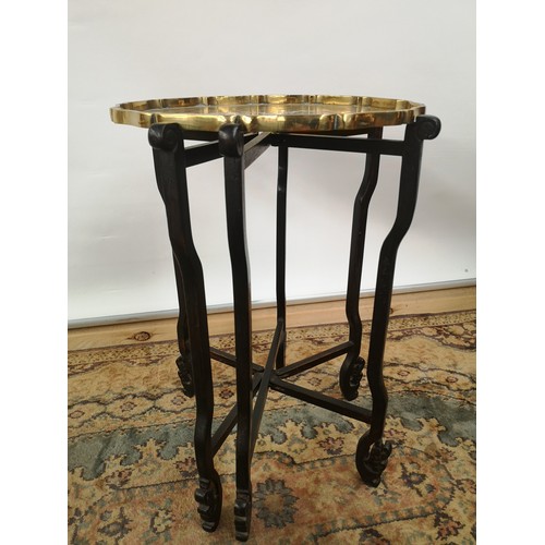 45 - A brass tea tray table with scalloped edging, engraved in a Japanese theme, supported on a 6 arm/leg... 