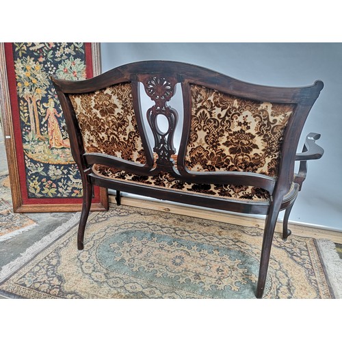 56 - Late 19th/ early 20th century double chairback settee, with a centre carved splat, scroll arms and u... 