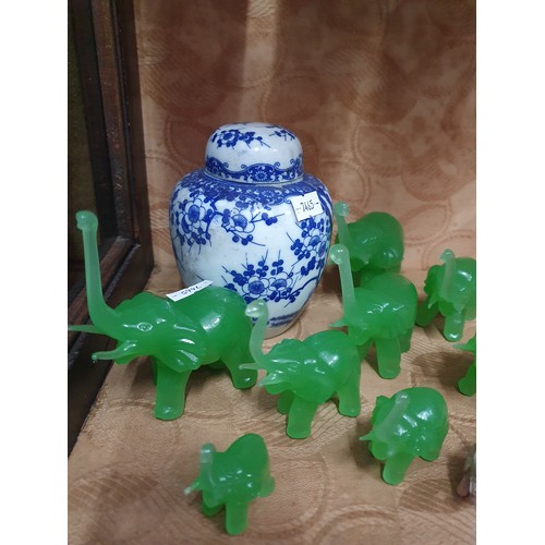 142C - Green ornamental elephants along with blue and white Chinese preserve pot.