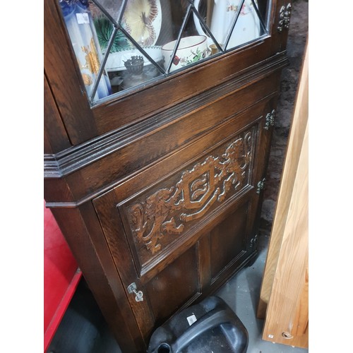 466D - Decorative dark wood corner cabinet carved with lion and crest deign