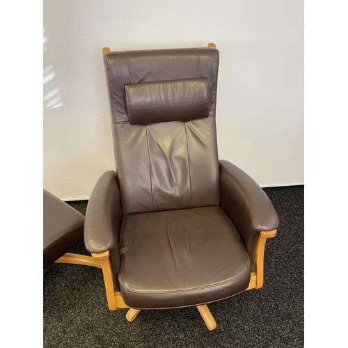 160 - An Ercol brown leather and light wood relaxer arm chair with matching stool.