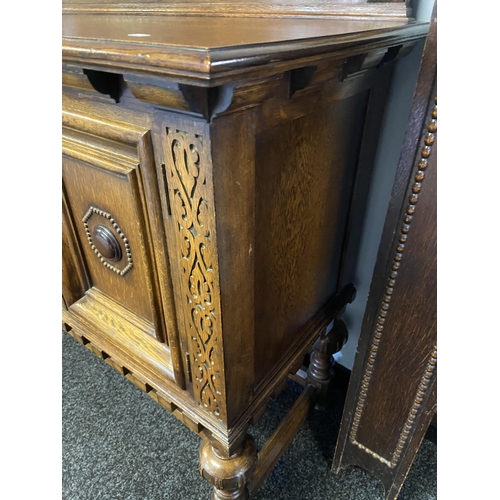 66 - An antique solid oak Art Deco sideboard designed on bulbous carved leg supports and decorative carve... 