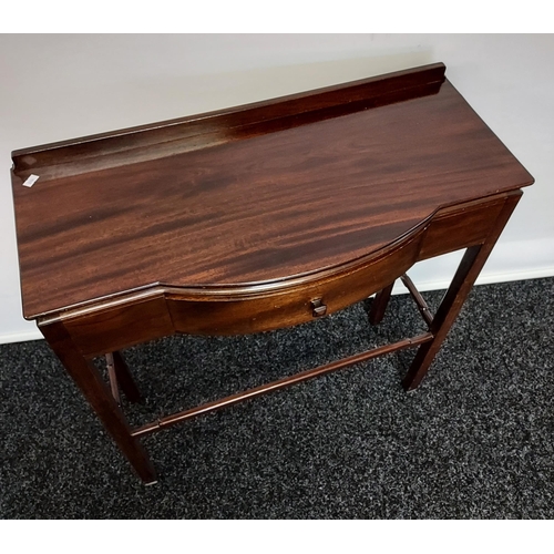 59 - A dark wood console table, with bow front single drawer, raised on square legs, united with stretche... 