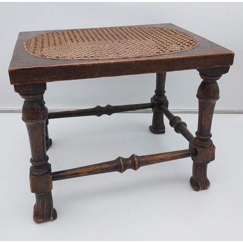 188 - A 19th century oak and bergere top stool. Designed with unusual linen fold style feet supports.