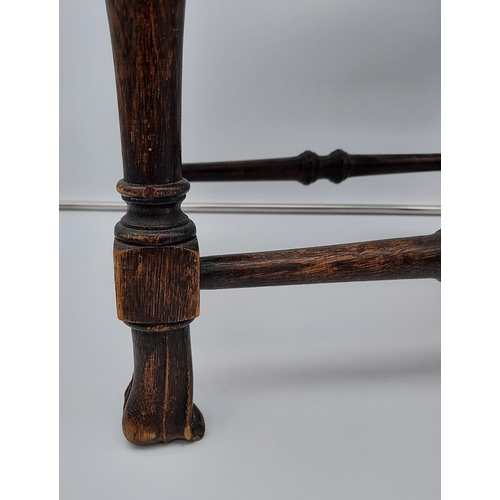 188 - A 19th century oak and bergere top stool. Designed with unusual linen fold style feet supports.