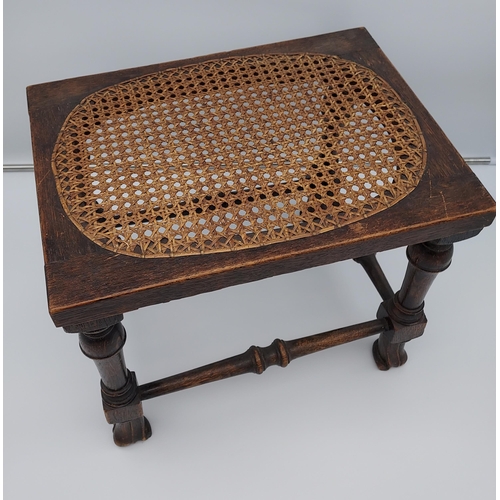 188 - A 19th century oak and bergere top stool. Designed with unusual linen fold style feet supports.