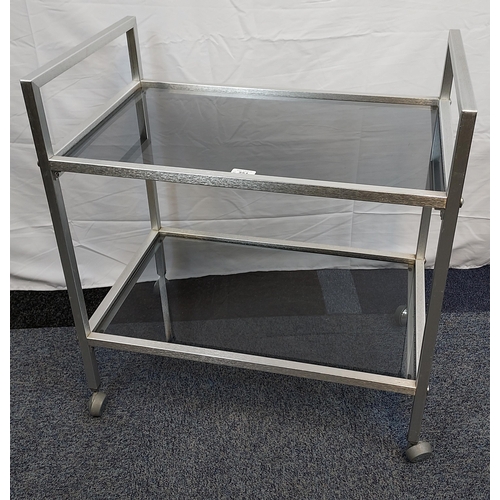 251 - A Mid century stainless steel and black glass two tier trolley.