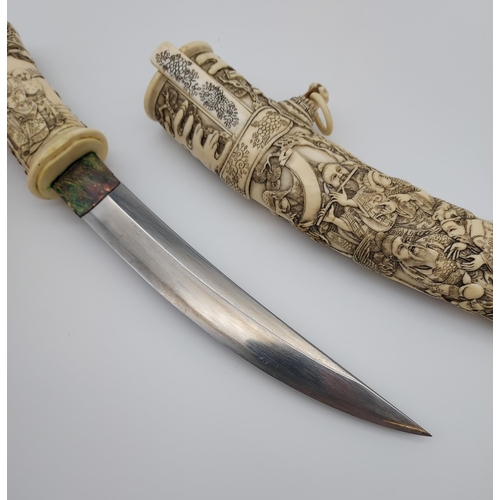 390 - A 19th/ early 20th century highly decorative Japanese Tanto. Carved from ivory. Saya has a smaller b... 