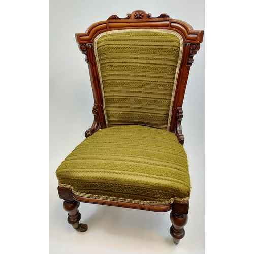 468 - A 19th century bedroom chair designed with a carved wooden frame, turned legs and green upholstery.