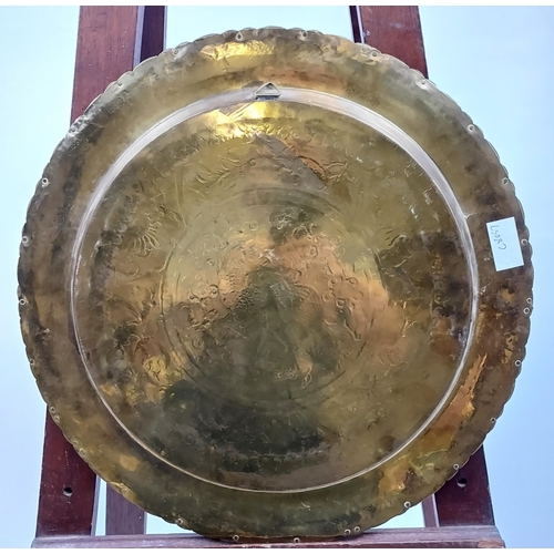 488 - A Gilt brass engraved wall charger depicting dragon/ horse. Made in Hong Kong. [41cm in diameter]