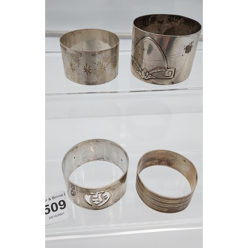 509 - Four various silver marked napkin rings together with an ornate Birmingham silver menu holder. [113.... 