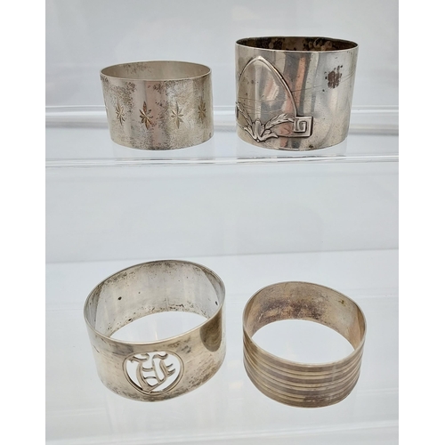 509 - Four various silver marked napkin rings together with an ornate Birmingham silver menu holder. [113.... 