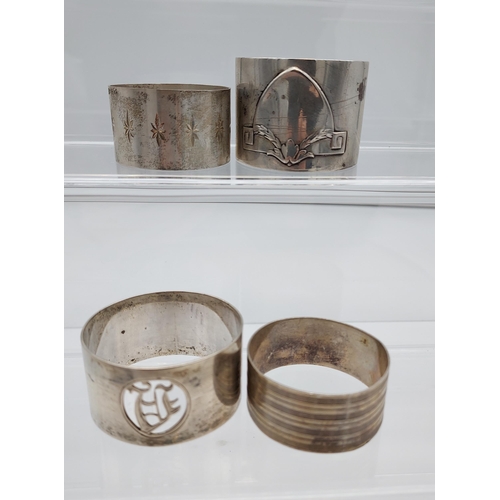 509 - Four various silver marked napkin rings together with an ornate Birmingham silver menu holder. [113.... 