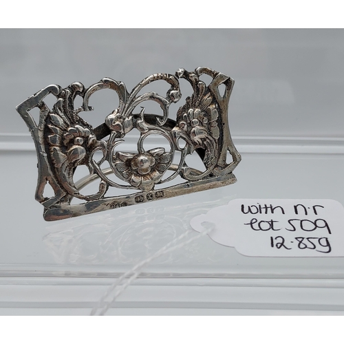 509 - Four various silver marked napkin rings together with an ornate Birmingham silver menu holder. [113.... 