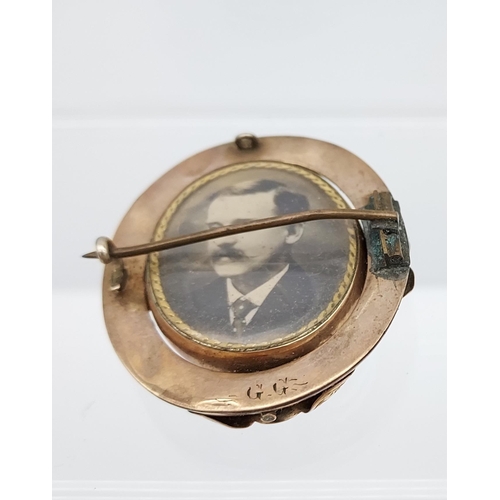 521 - A Yellow metal ornate mourning brooch showing military gentleman, photograph.