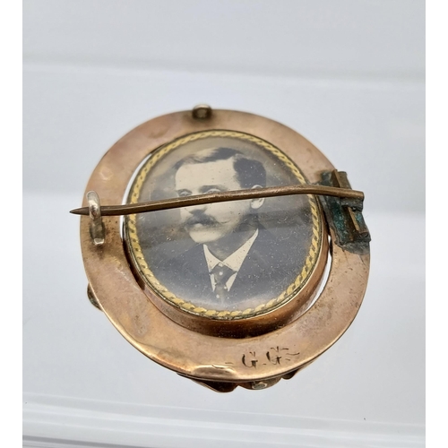 521 - A Yellow metal ornate mourning brooch showing military gentleman, photograph.