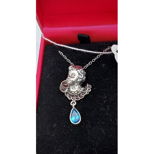 543 - A silver pendant necklace of a figure with pear shaped blue topaz drop