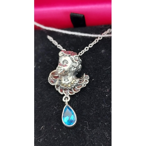 543 - A silver pendant necklace of a figure with pear shaped blue topaz drop