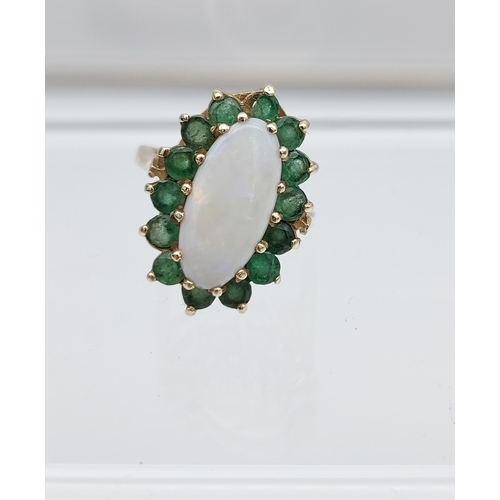 552 - A Beautiful example of a ladies 9ct gold, large opal and emerald cluster ring. [15.2x7.0mm-opal]