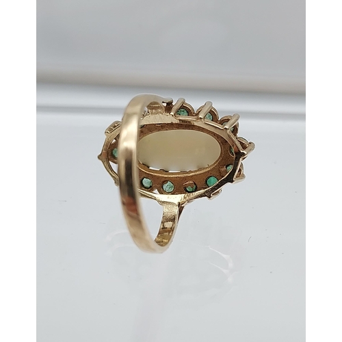 552 - A Beautiful example of a ladies 9ct gold, large opal and emerald cluster ring. [15.2x7.0mm-opal]