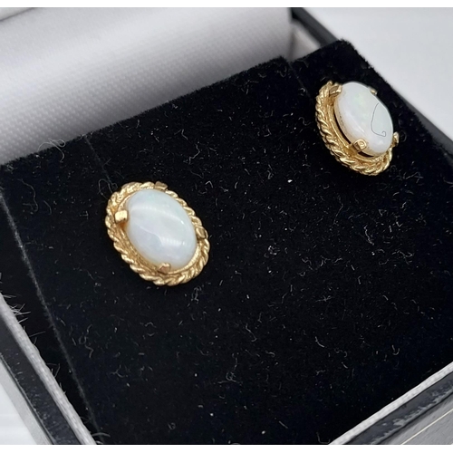 555 - A Pair of 9ct gold and opal earrings.