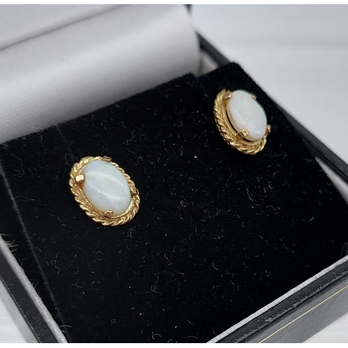 555 - A Pair of 9ct gold and opal earrings.