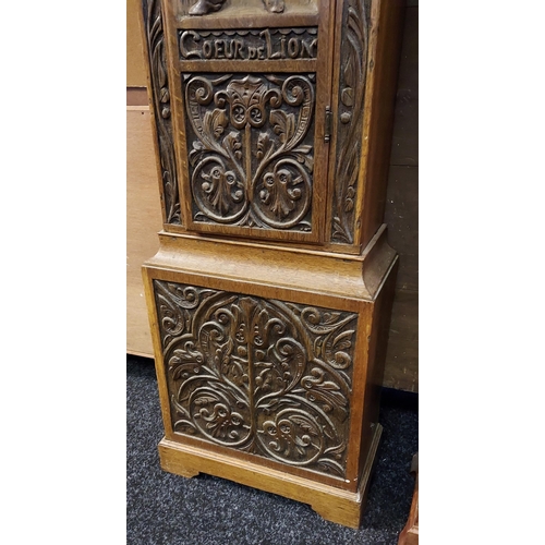 57 - A Unique Antique long cased grandfather clock depicting a hand carved casing which shows Richard Coe... 