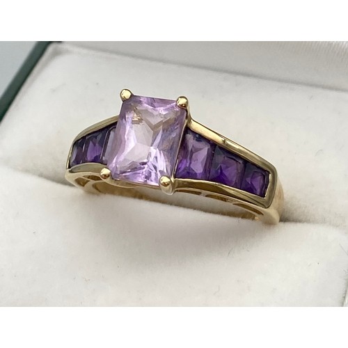 4 - A Ladies 9ct yellow gold ring set with purple cut stones. [Ring size N] [3.02Grams]