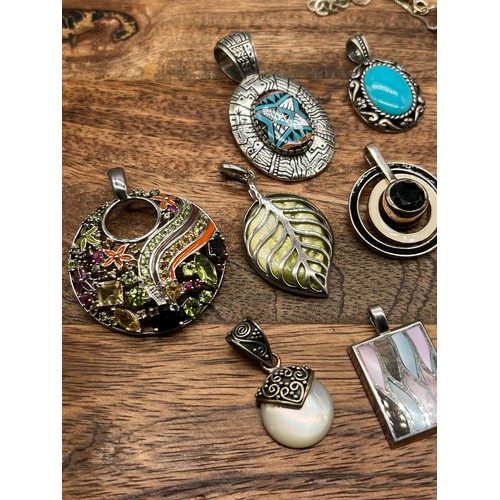 45 - A Collection of contemporary silver pendants [14] with enamel and stone designs.