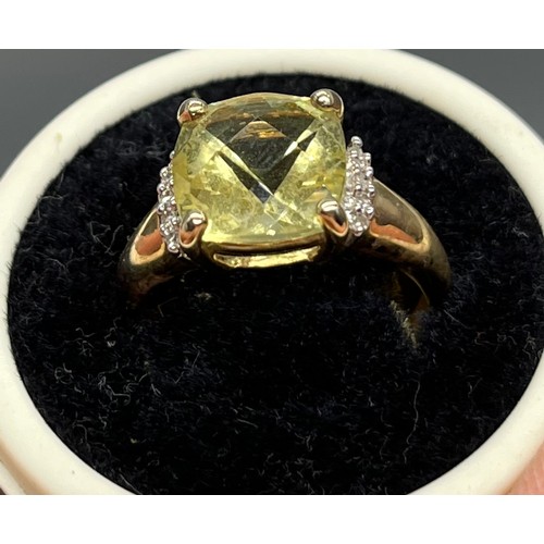 40 - A Ladies 9ct yellow gold ring set with a large pale yellow stone off set by diamonds to each shoulde... 