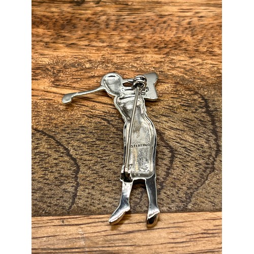 97 - A silver figural lady golfer of brooch form. (5cm in length)