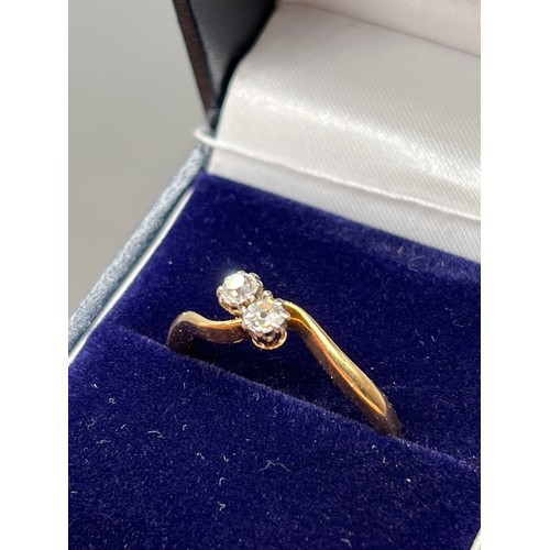 130 - An 18ct yellow gold and platinum set diamond cross over ring of 35 points. [Ring size R] [3.20Grams]