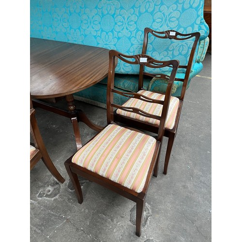 34 - A Mahogany small dining table with two carvers and four chairs. Comes with extra leaf.